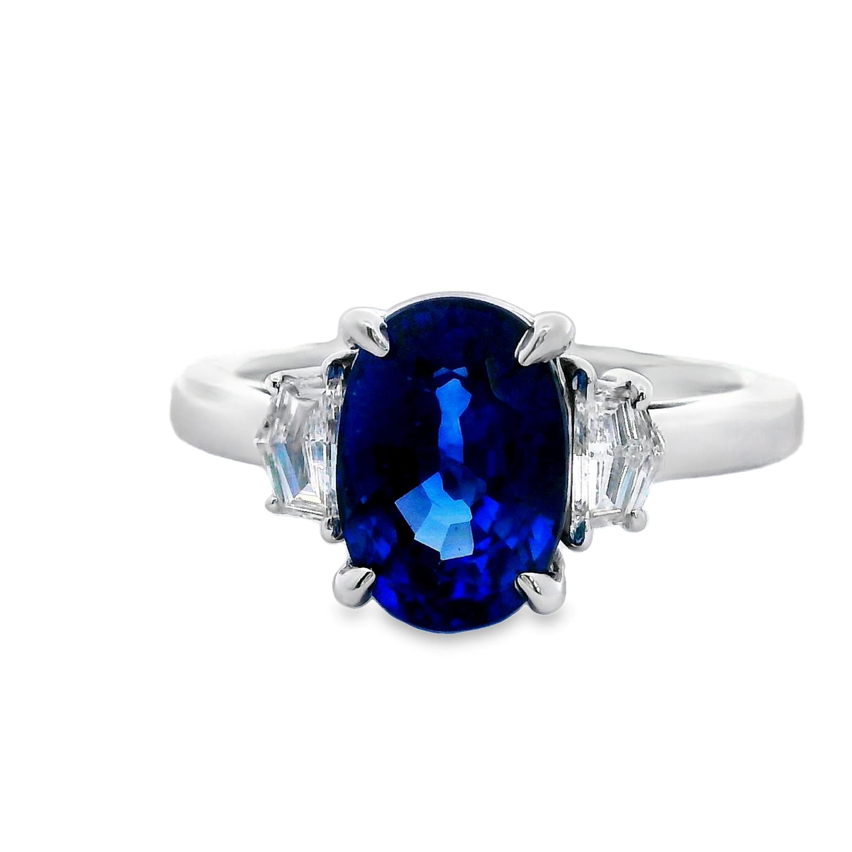 18Kt White Gold 3 Stone Ring with a 3.25Ct Oval Sapphire (9.5x7mm) and 2.29cttw Natural Cadillac Shaped Diamonds (Color G-H, Clarity SI1)