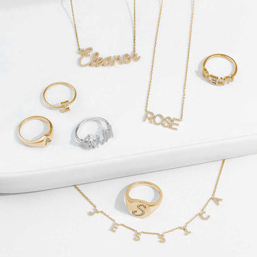 Gold and silver jewelry set including necklaces and rings on a white surface