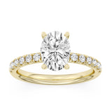 Yellow gold engagement ring with oval-cut center diamond and diamond halo setting.