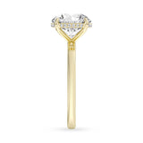 Side profile view of a yellow gold engagement ring with elevated round diamond solitaire setting.