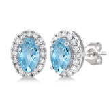 White gold stud earrings featuring oval blue gemstones surrounded by diamond halos.